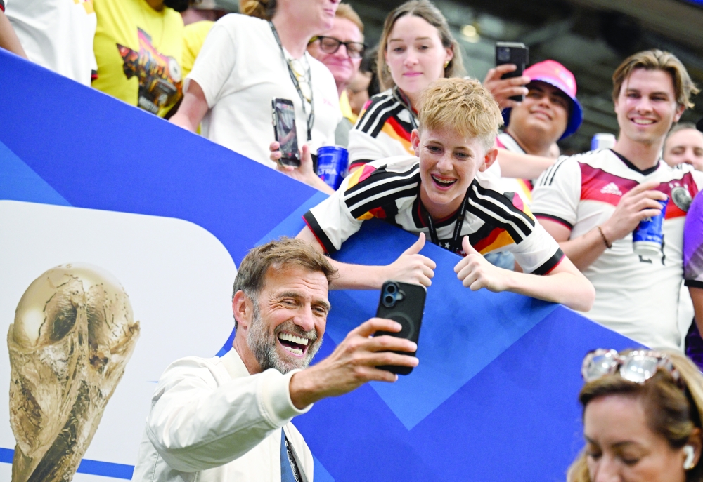 Former manager Juergen Klopp takes a selfie with fans after the match. — Reuters