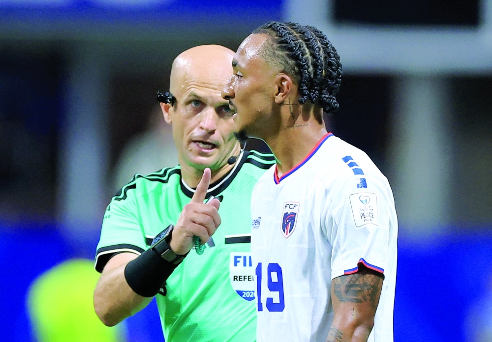 Referee Adham Makhadmeh with Cape Verde's Dailon Livramento. — REUTERS