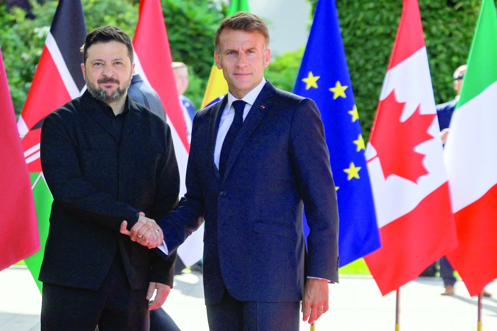 France's President Emmanuel Macron greets Ukraine's President Volodymyr Zelensky ahead of the working session with G7 leaders and Ukraine during the G7 summit, in Evian, eastern France. — AFP
