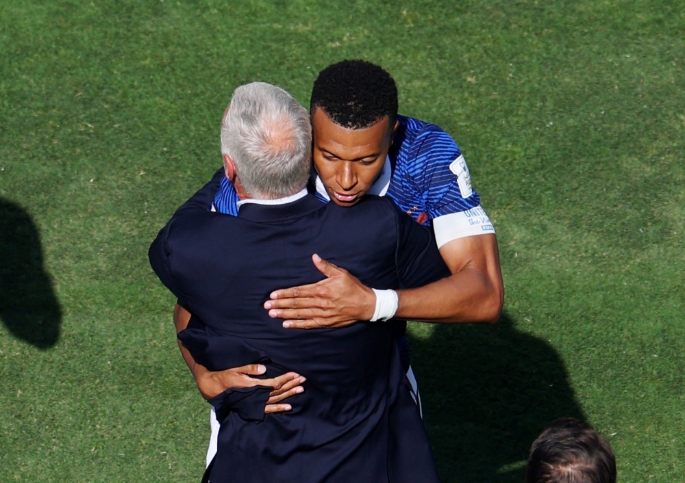  
France's Kylian Mbappe celebrates scoring their first goal with coach Didier Deschamps  