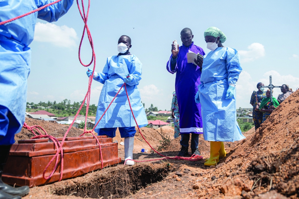 Teams from the International Federation of the Red Cross and Red Crescent Societies prepare for burial at Mbiyo cemetery in Bunia. — AFP