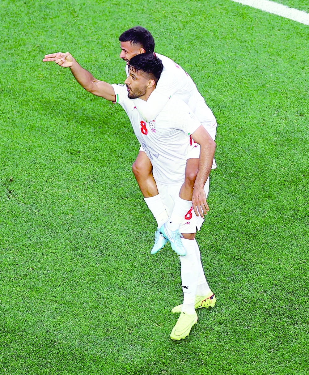 
Iran's Mohammad Mohebbi celebrates scoring their second goal with Mehdi Ghayedi. — Reuters