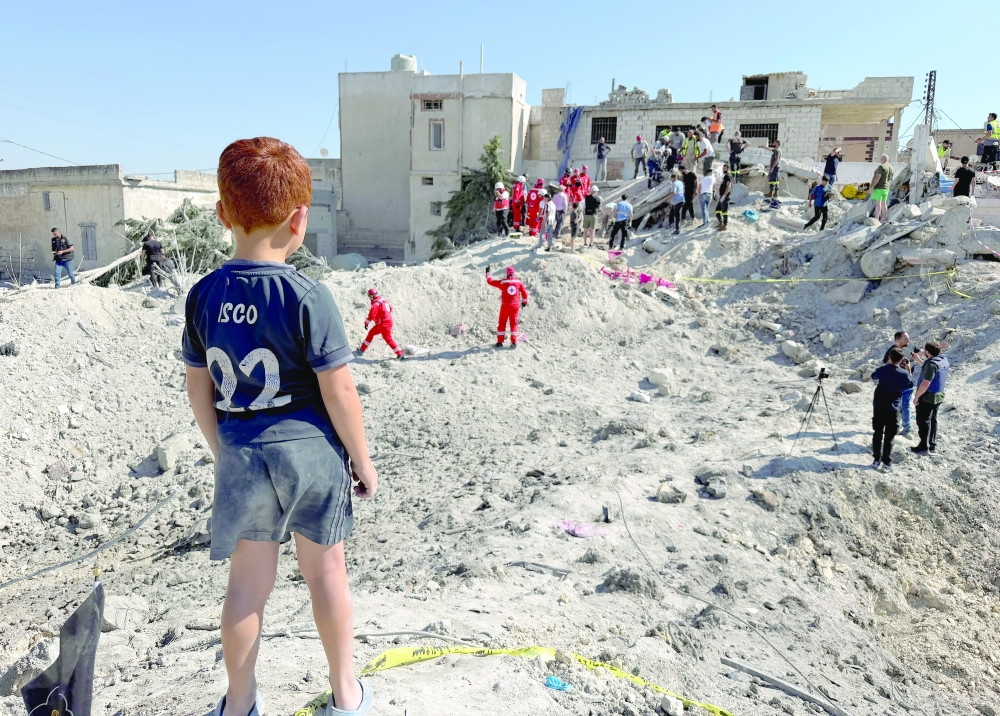 A child stands next to the rubble of a building damaged in an Israeli strike in Qennarit, southern Lebanon, on Saturday. — Reuters
