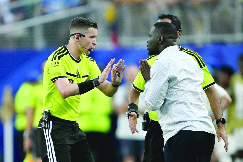 French referee Letexier speaks to Ivory Coast's head coach Emerse during the match. — AFP