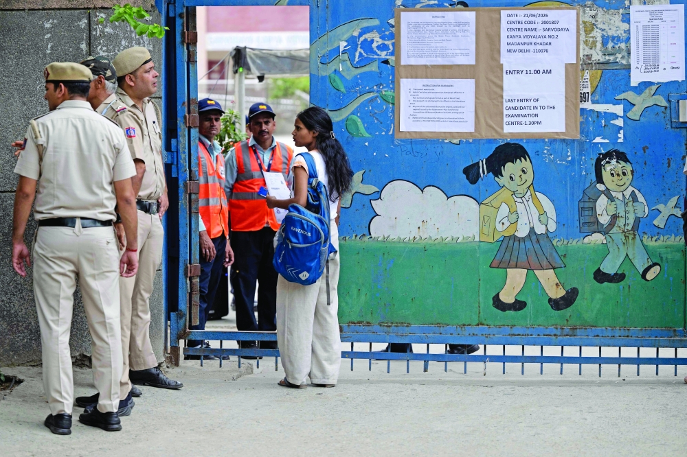 A medical student speaks to a police personnel upon her arrival to appear for the NEET-UG re-examination in New Delhi. — AFP