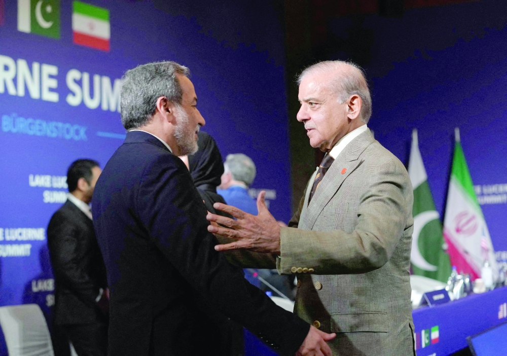 Iran's Foreign Minister Abbas Araqchi (L) and Pakistan's Prime Minister Shehbaz Sharif greet each other. — AFP