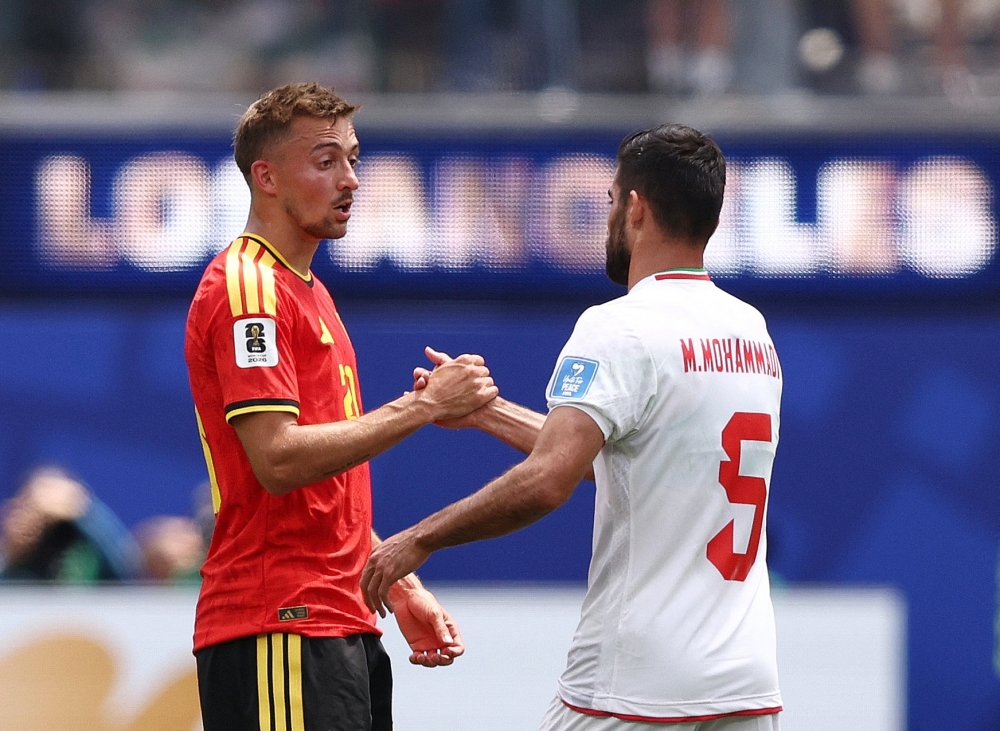  
Belgium's Castagne with Iran's Milad after the match. — Reuters