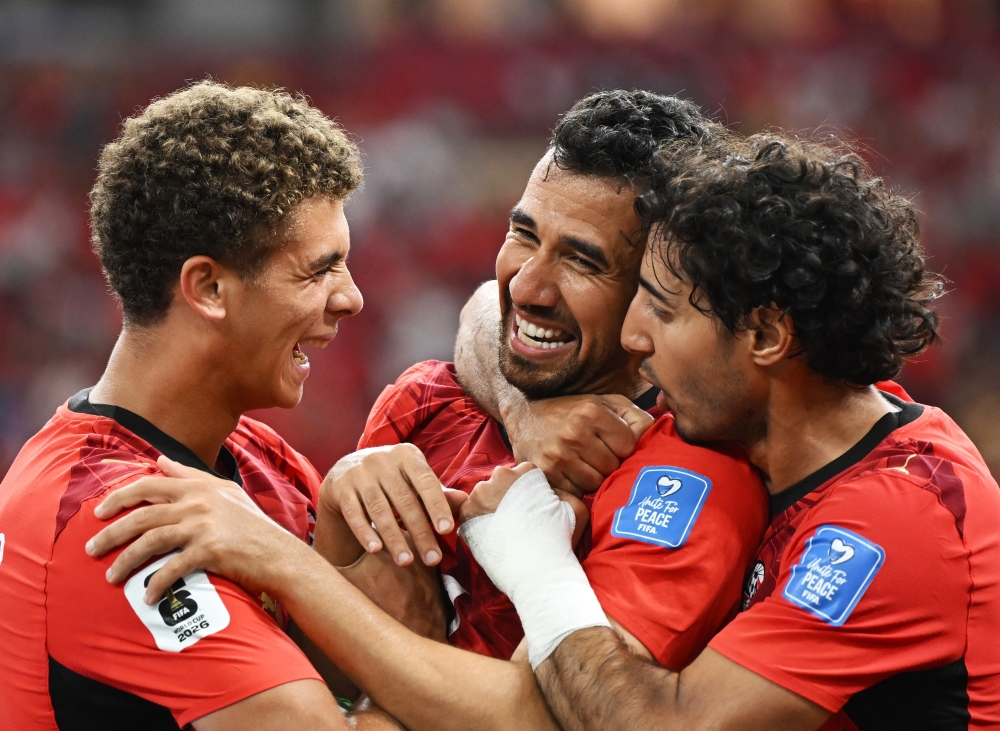  
Egypt's Trezeguet  celebrates scoring their third goal with Hamza and Hany. — Reuters  