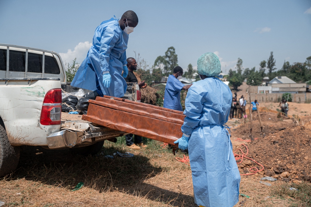 Teams from the International Federation of the Red Cross and Red Crescent Societies offload at Mbiyo cemetery the body of a fourth orphan who died from Ebola virus disease at an orphanage in Bunia, Ituri Province, June 19, 2026. 