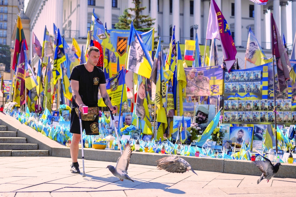 Ukrainian war veteran walks at a makeshift memorial for Ukrainian service members in Kyiv. — Reuters
