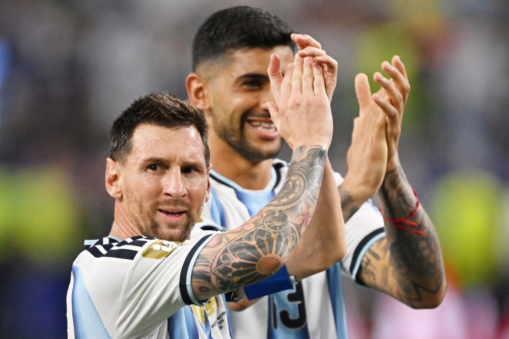  
Argentina's Lionel Messi and Cristian Romero celebrate after the match 