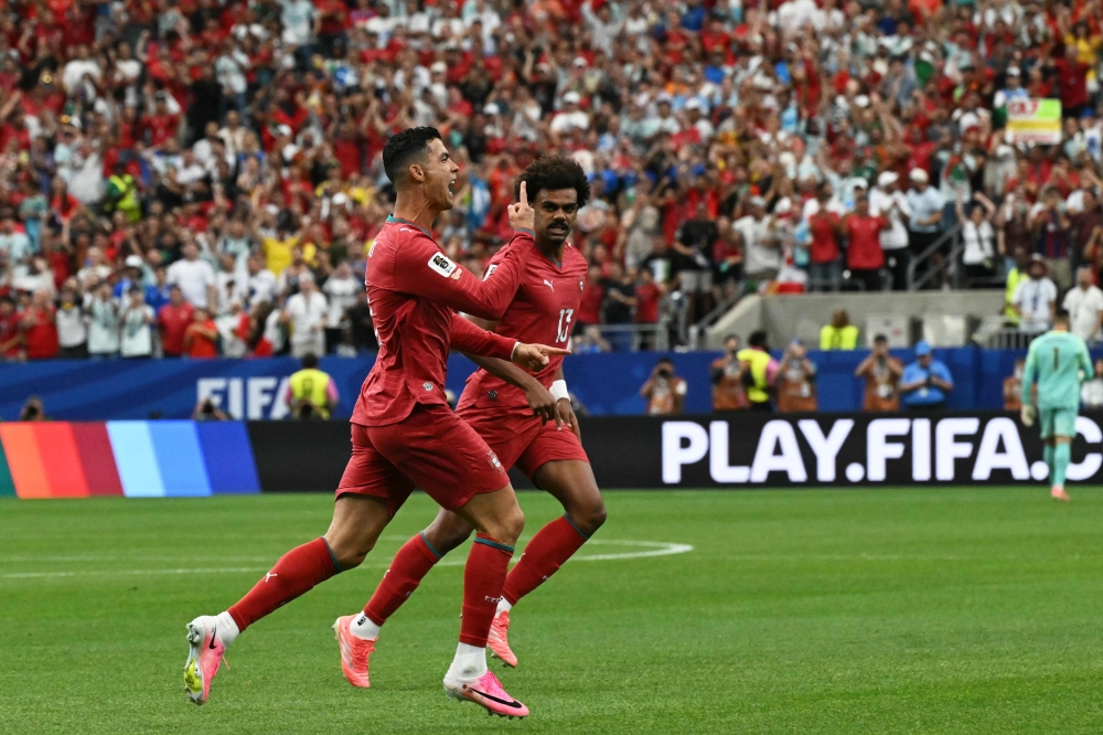 Portugal's Ronaldo (L) celebrates after scoring the opening goal. — Reuters    