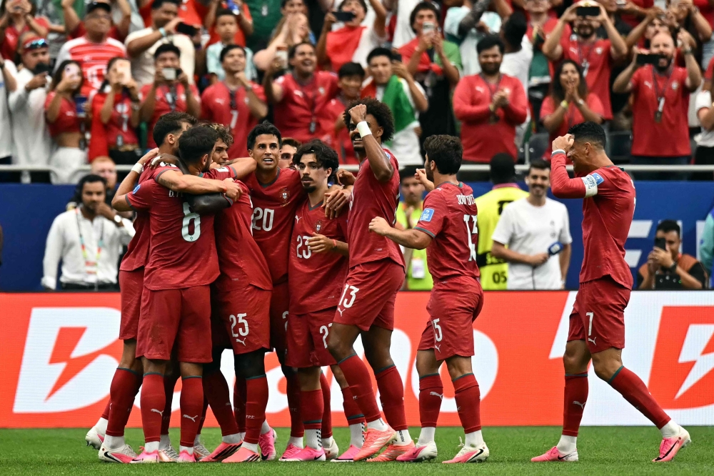Portugal players celebrate scoring the second goal. — AFP