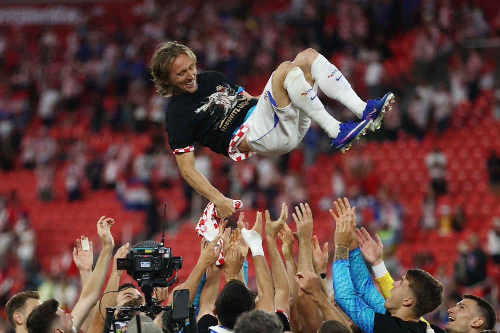 Croatia's #10 Luka Modric is lifted up. — AFP