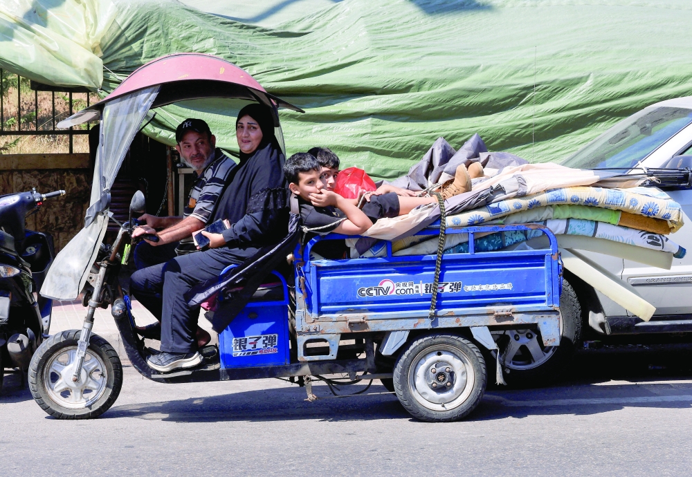 
A family loads their belongings into a small cart as they prepare to return home following an interim deal between the US and Iran, after living in temporary tents in Beirut, Lebanon, on Wednesday. — Reuters 