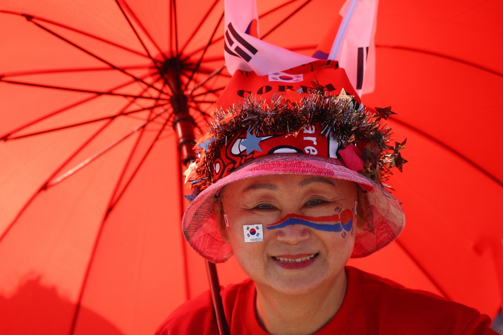  
A South Korea fan poses for a photo as they gather to watch the match in Los Angeles  
