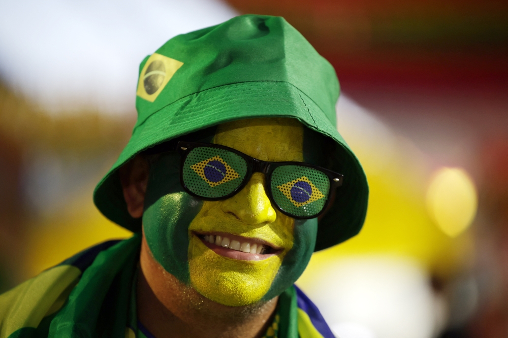  
General view of a Brazil fan wearing face paint and glasses 