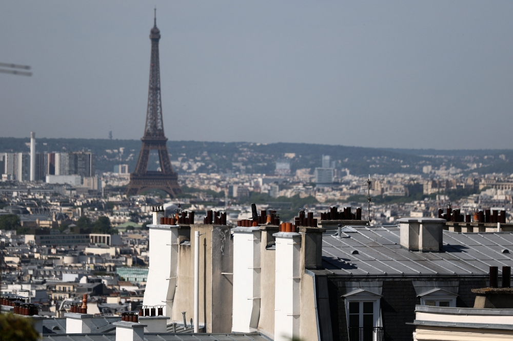 City rooftops and chimney stacks of residential apartment buildings, and the Eiffel Tower, as temperatures rise in Paris, during a heatwave affecting a majority of the country