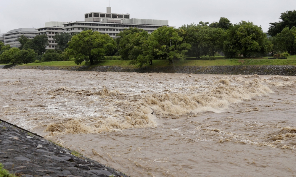 The Kamo River, swollen by heavy rain, flows rapidly in Kyoto, Japan June 26,  2026