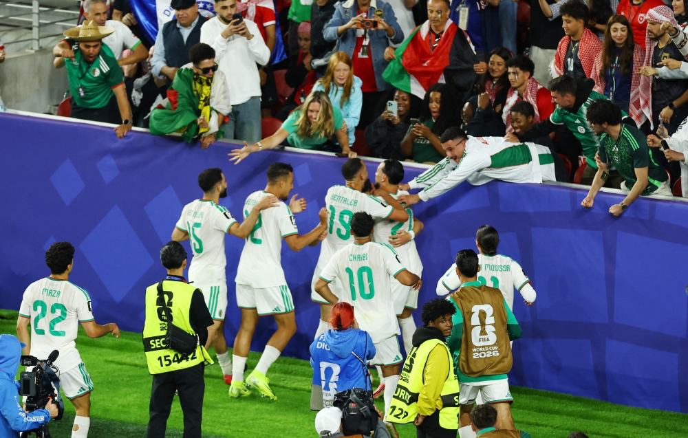  
Algeria's Amine Gouiri celebrates scoring their second goal with teammates and fans  