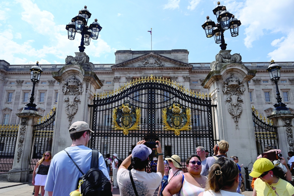 People gather outside Buckingham Palace on Friday. — Reuters