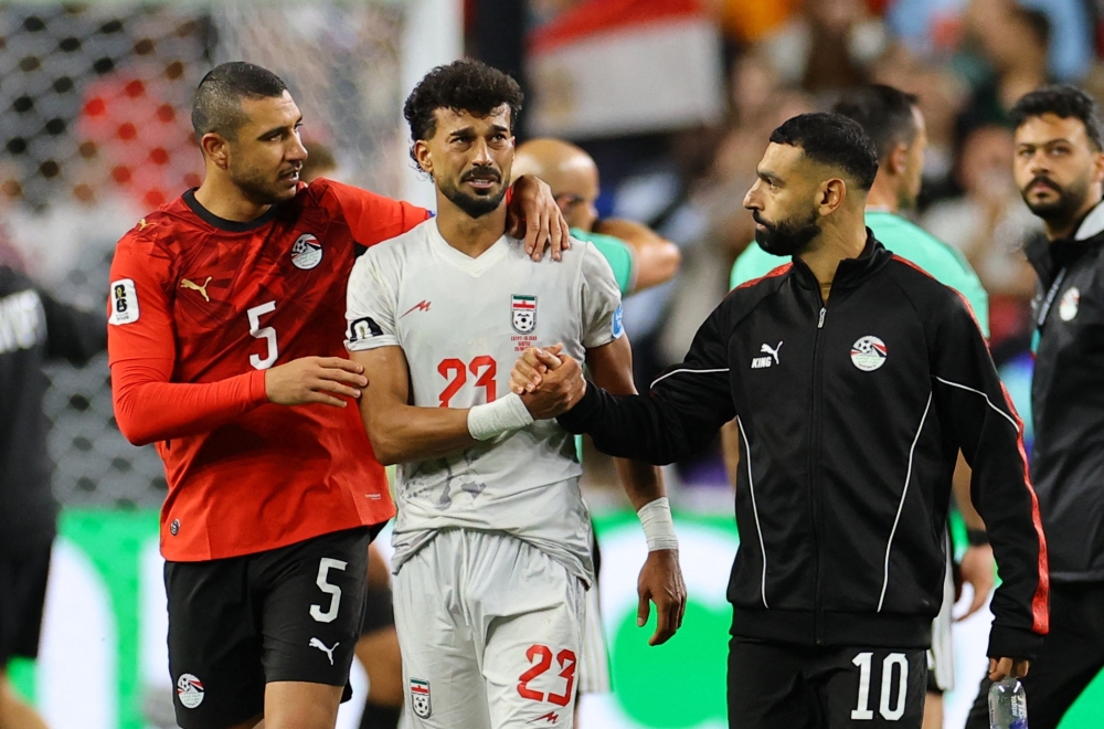  
Iran's Rezaeian looks dejected as Egypt's Salah and Rabia shake his hand. — Reuters  