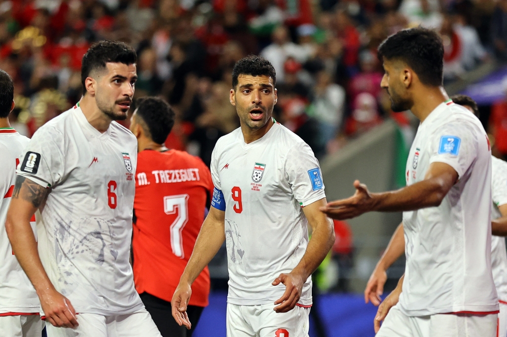  
Iran's Mehdi Taremi and Saeid Ezatolahi react. — Reuters  