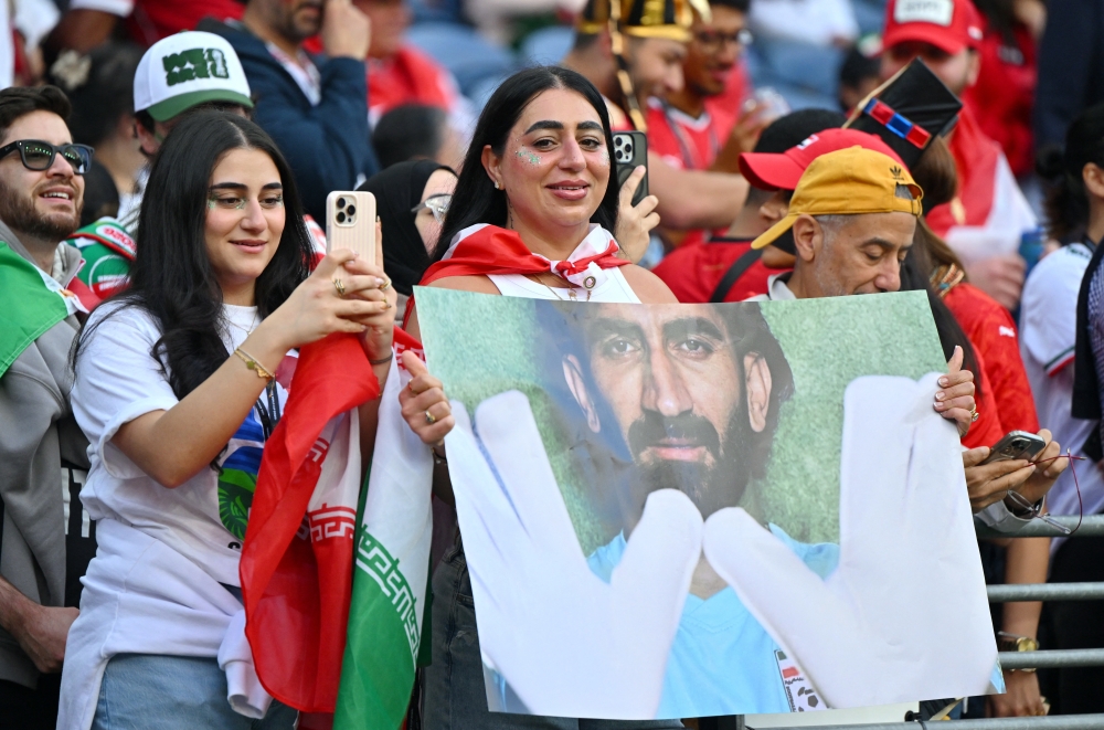  
Iran fans hold up a poster of Iran's Alireza Beiranvand inside the stadium before the match 