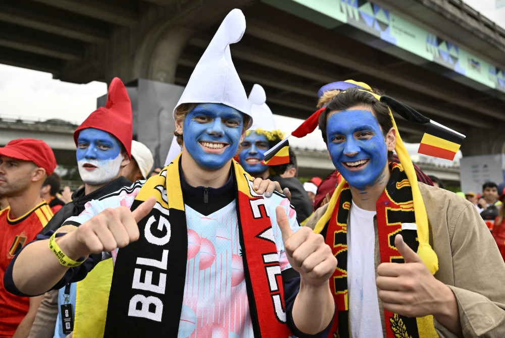  
Belgium fans dressed as Smurfs react as they march to the stadium ahead of the match 