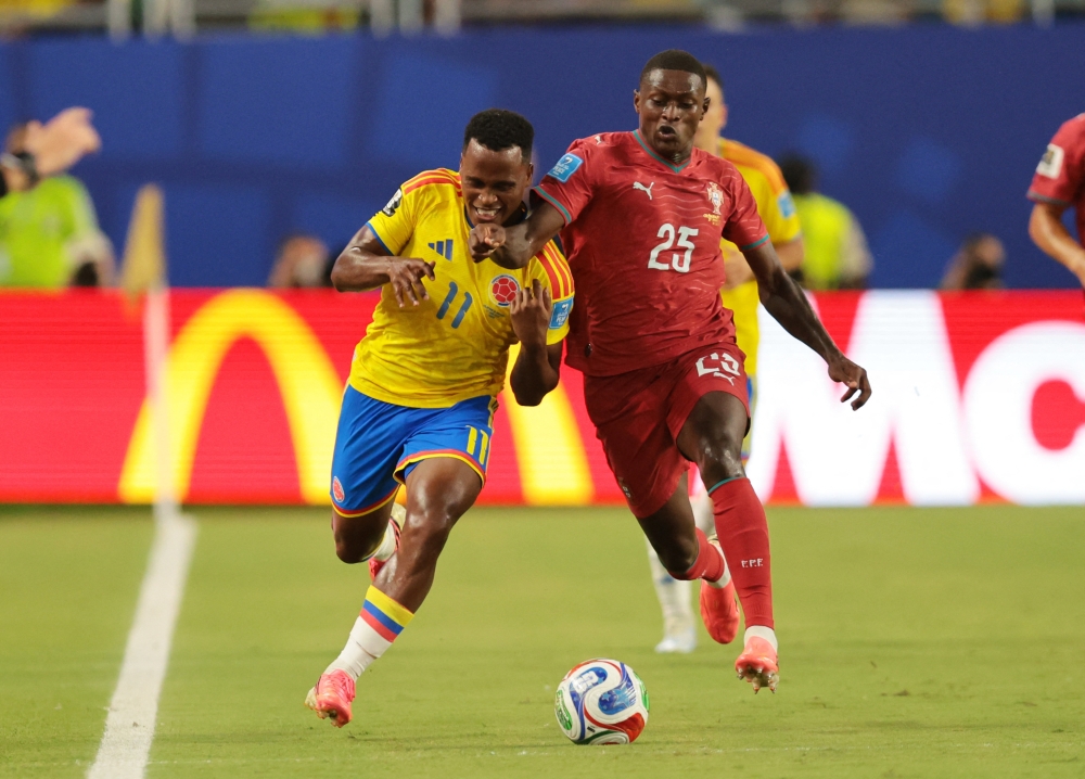  
Colombia's Arias in action with Portugal's Mendes. — Reuters