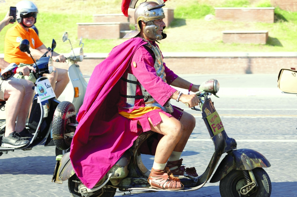 A man wearing a costume drives a Vespa near the Fori Imperiali on the last day of "Vespa Roma 2026 - 80 Years of an Icon”, a four-day global gathering marking the 80th anniversary of the iconic Italian scooter brand, in Rome, Italy, June 27, 2026. REUTERS/Remo Casilli