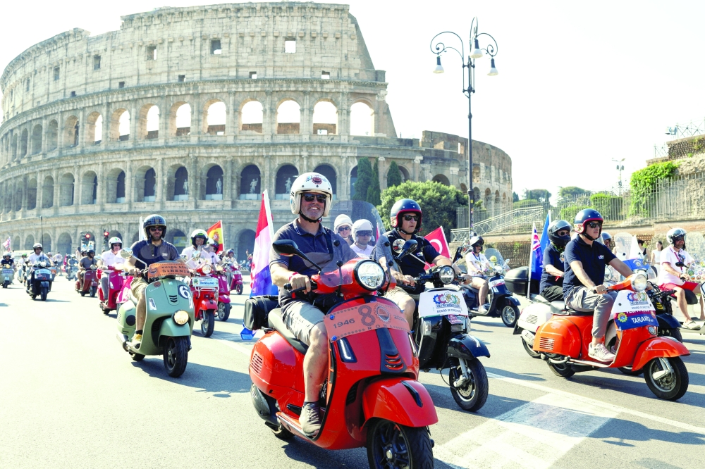Vespa riders drive past the Colosseum the last day of "Vespa Roma 2026 - 80 Years of an Icon”, a four days global gathering marking the 80th anniversary of the iconic Italian scooter brand, in Rome, Italy, June 27, 2026. REUTERS/Remo Casilli     TPX IMAGES OF THE DAY     