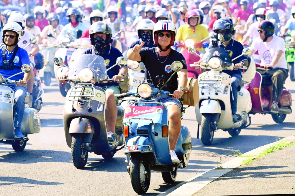 Vespa enthusiasts from around the world ride during the parade of the Vespa World Days marking the 80th anniversary of the iconic Italian brand of scooters in Rome on June 27, 2026. (Photo by Alberto PIZZOLI / AFP)
