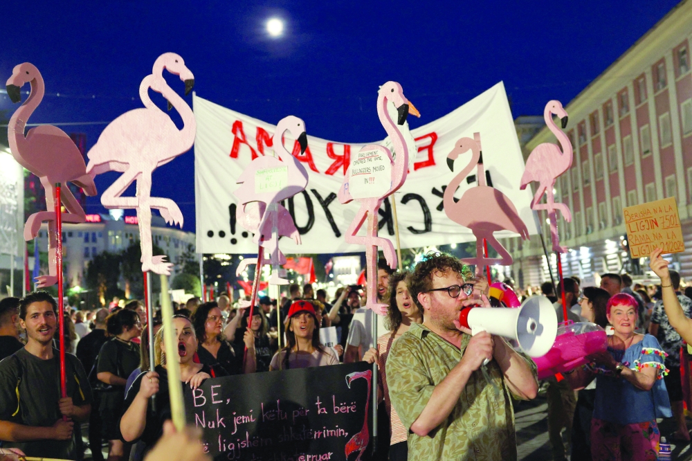 Protesters hold flamingo-shaped placards as they demonstrate in Tirana, Albania. — Reuters 