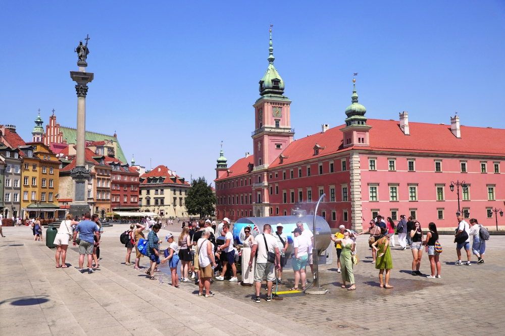 People gather at Castle Square under water curtains and near a tanker providing free drinking water in Warsaw, Poland. — Reuters 