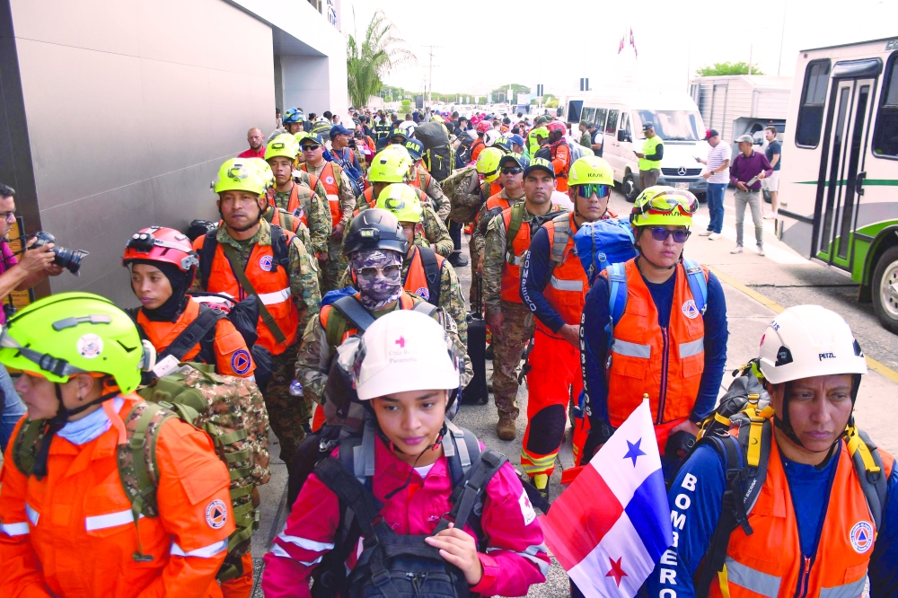 Panamanian rescuers and firefighters stand on arrival at the Arturo Michelena international airport in Valencia, Venezuela. — AFP