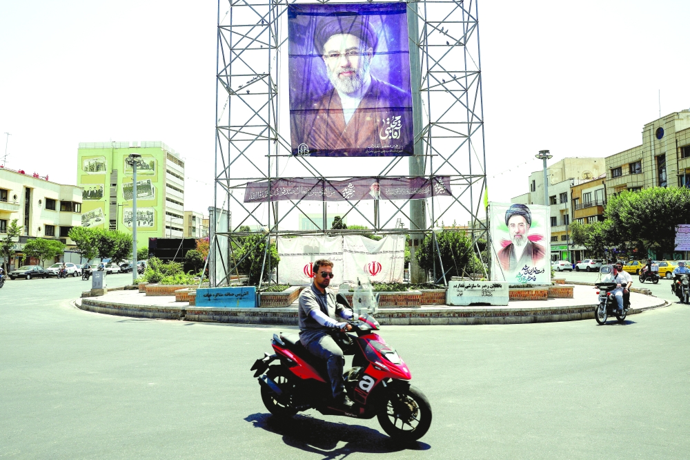 People ride past a banner with a picture of Iran's Supreme Leader, Mojtaba Khamenei, in Tehran. — Reuters