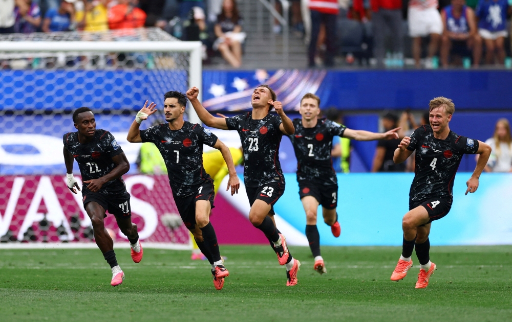  
Canada's Eustaquio celebrates first goal with teammates. — Reuters