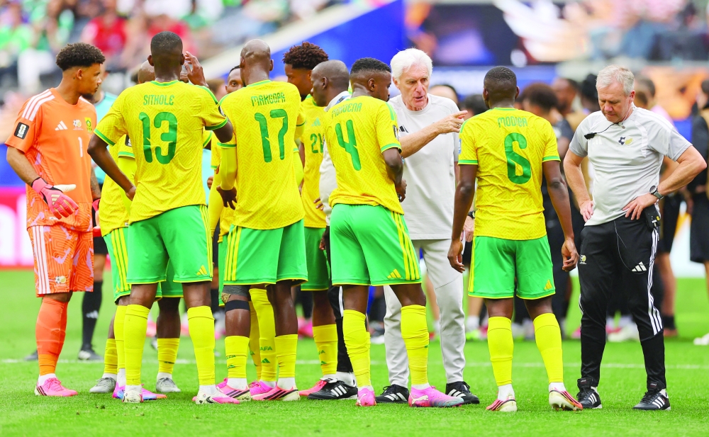 South Africa coach Hugo Broos speaks with players during a hydration break. — Reuters