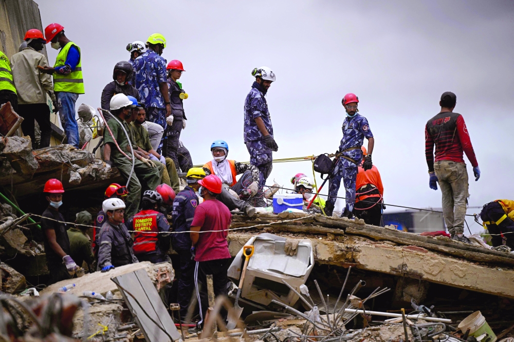 Rescuers and firefighters work at the site of a collapsed building in the San Bernardino neighborhood of Caracas, Venezuela, on June 28, 2026, following earthquakes. Thousands of rescuers, relatives and volunteers dig day and night through mounds of concrete to find survivors of the earthquakes that struck Venezuela more than three days ago, leaving nearly 1,500 dead and tens of thousands missing. (Photo by Federico PARRA / AFP)
