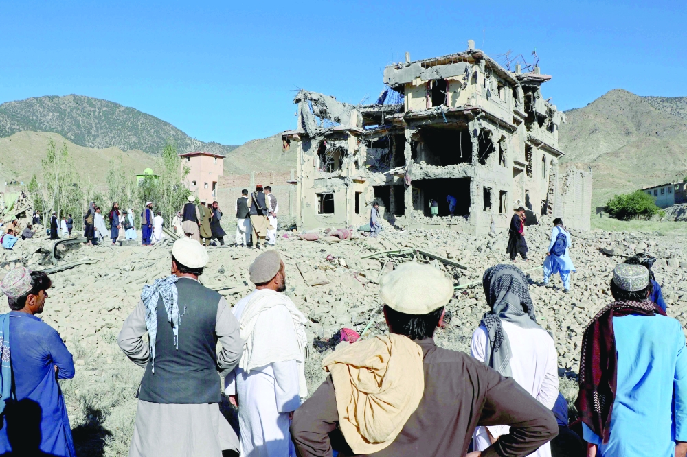 Afghan residents look at the remains of a building damaged in a Pakistani air strike at a village in Tsamkani district of Afghanistan's Paktia province. — AFP