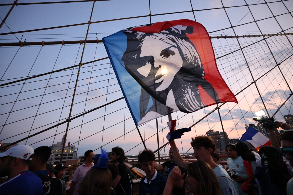  
France fans walk across Brooklyn Bridge ahead of their Round of 32 match tomorrow against Sweden 