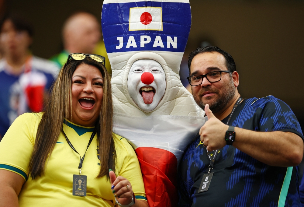  
Japan and Brazil fans pose for a photo inside the stadium before the match 