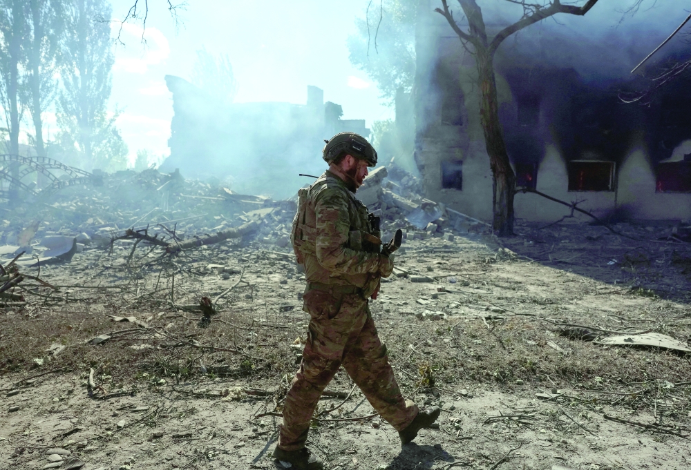 A serviceman of the National Guard of Ukraine walks near destroyed apartment buildings in Donetsk region. — Reuters 