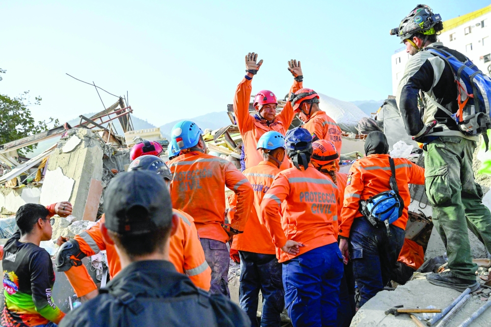 Venezuelan Civil Protection members work at the site of a collapsed building in Caraballeda, La Guaira state. — AFP
