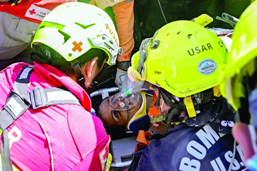 
An international rescue team assists a survivor in Catia La Mar on Thursday. — AFP 