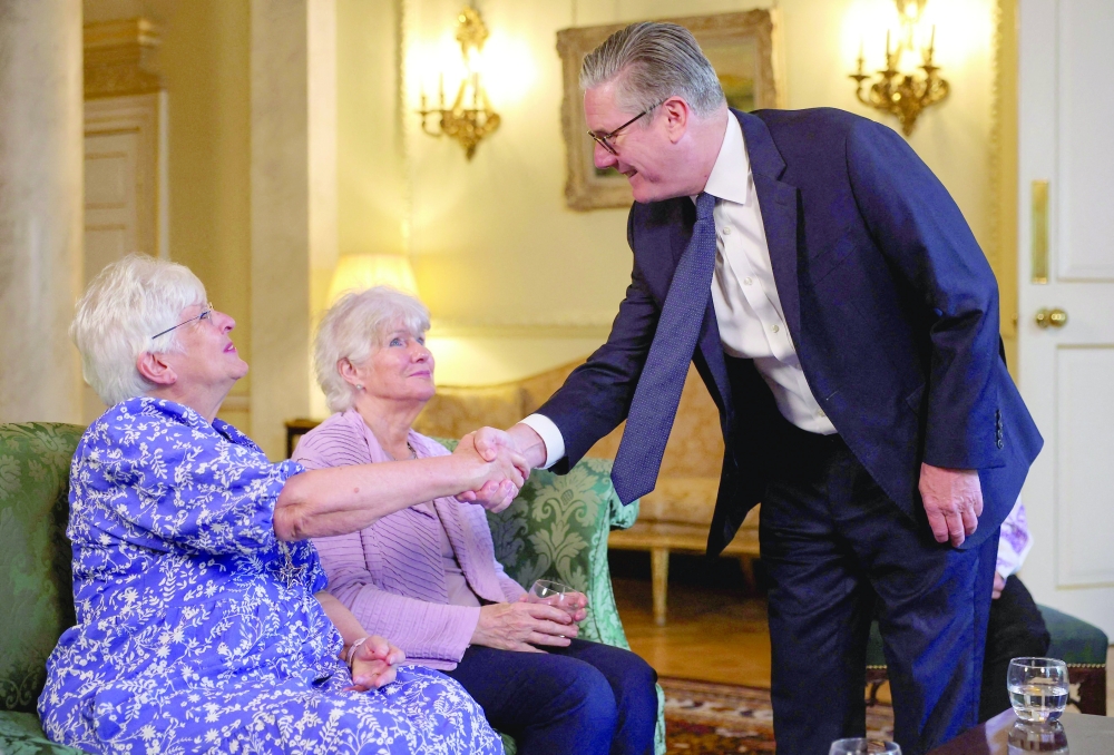 
Britain’s Prime Minister Keir Starmer (R) welcomes campaigners for a meeting to discuss historical forced adoption, at Downing Street in London on Thursday. — AFP 