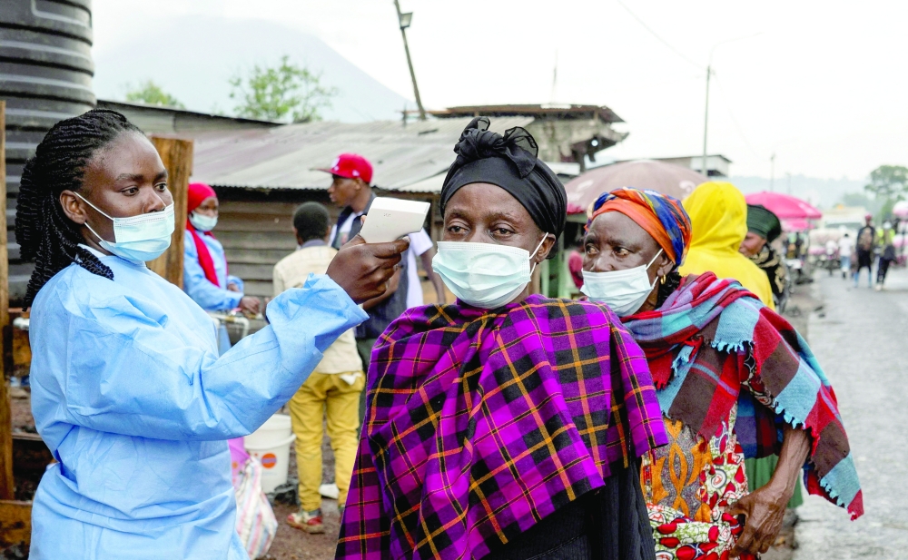 
A health worker takes the temperature of a woman passing through the Kanyaruchinya checkpoint. — AFP file photo 