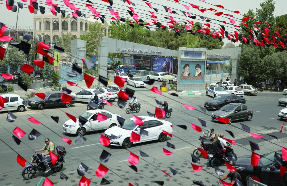 
Red and black pennants hang above a street as vehicles pass by during preparations for a farewell ceremony for Ayatollah Ali Khamenei in Tehran, on Thursday. — Reuters 