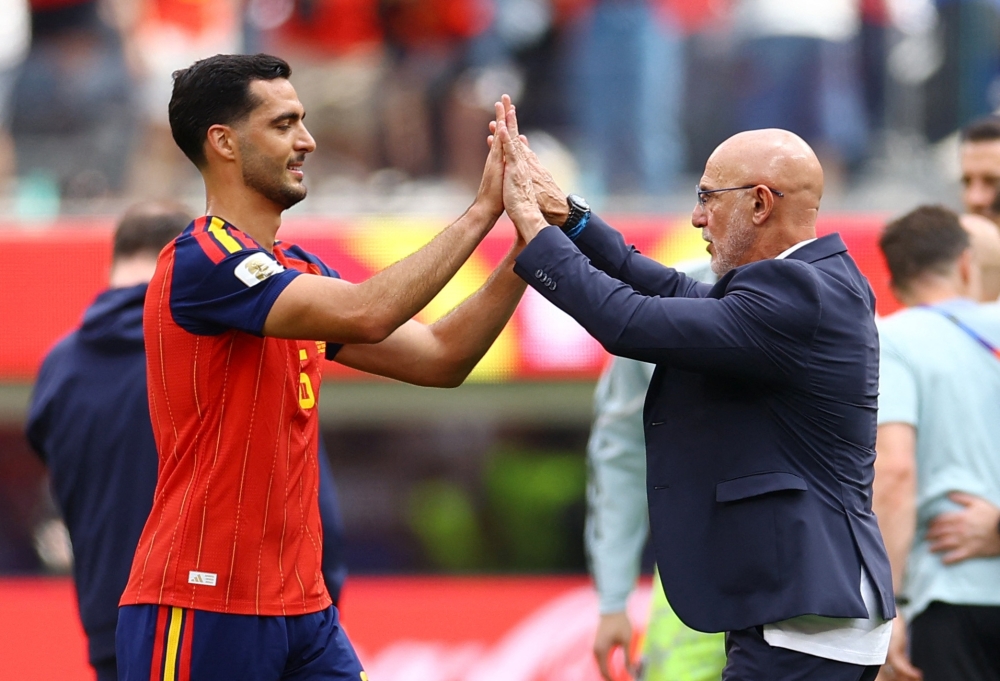  
Spain's Merino and coach Fuente celebrate after the match. — Reuters